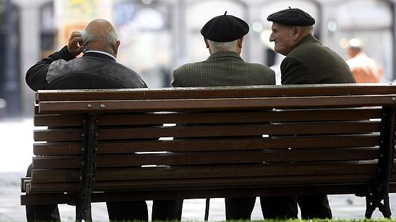 Tres jubilados conversan en un banco de Bilbao.