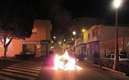 Varios compatriotas del fallecido han quemado contenedores en Roquetas de Mar.