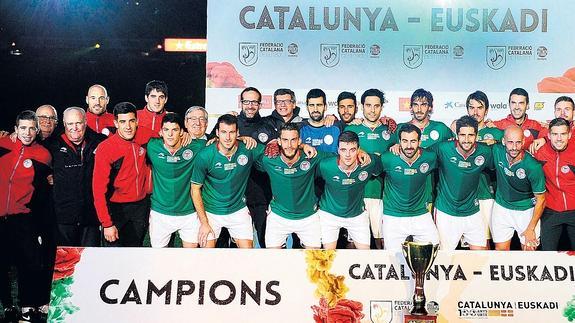 Los jugadores y el cuerpo técnico de Euskal Selekzioa, con el trofeo que les acredita como ganadores del duelo en el Camp Nou.