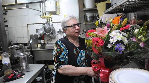 Carmen Redondo recoge un ramo de flores en la cocina del histórico asador Orense. 