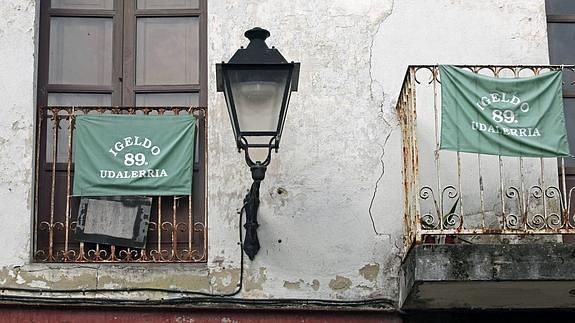 Dos pañuelos con el nombre de Igeldo cuelgan de dos balcones.