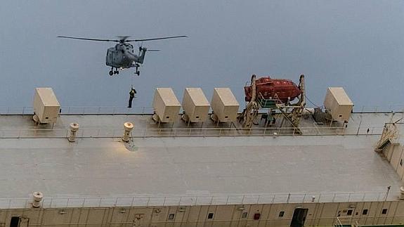 Un helicóptero francés traslada a uno de los rescatadores holandeses a la cubierta escorada del 'Modern Express'.