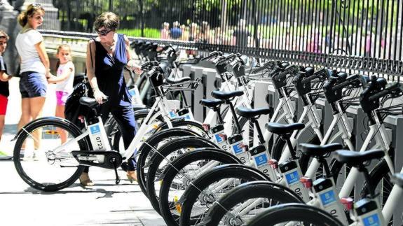 Una mujer utiliza el servicio de alquiler de una bicicleta eléctrica en Madrid. 