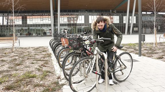 Un joven deja su bicicleta en el aparcamiento situado en el exterior de la estación de autobuses