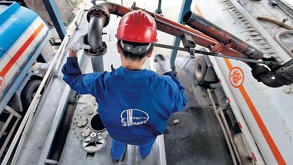 Un operario de la petrolera china Sinopec llena camiones cisterna en la factoría de Wuhan, en la provincia de Hubei.
