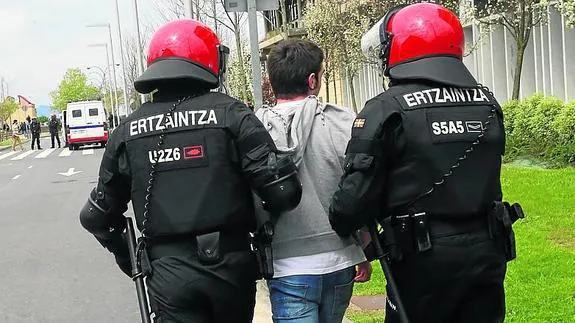 Dos ertzainas se llevan a un manifestante en Leioa el martes.