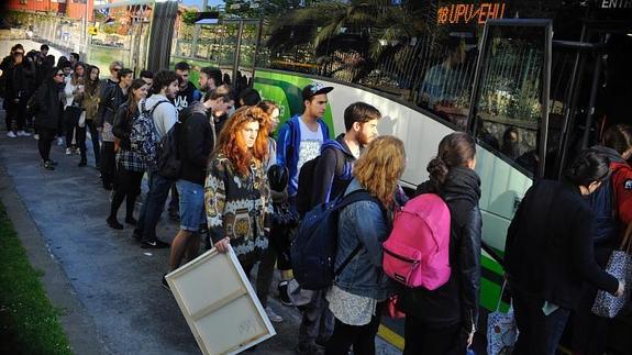 Decenas de jóvenes hacen cola para coger el autobús.