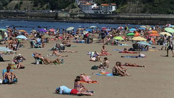 Cientos de personas disfrutan de un día de sol en la playa de Ereaga.