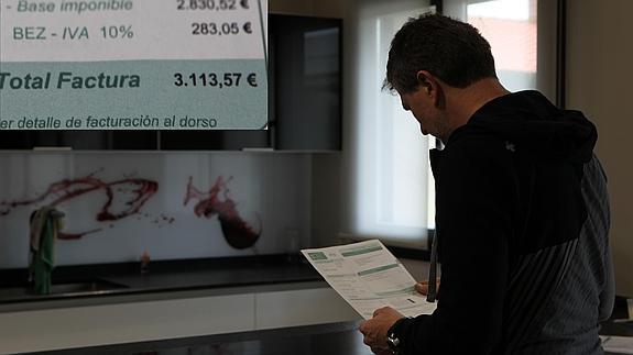 El joven mira una de las facturas que ha tenido que abonar