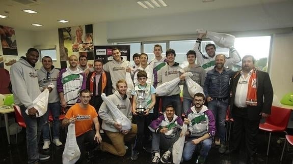 Los jugadores, jamón en mano, tras la visita al patrociandor