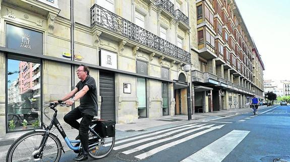 Un hombre circula en bicicleta frente a los locales de la calle San Antonio. 