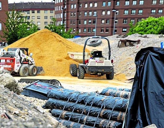 Restos de la obra, con tuberías de amianto tapadas, en una calle junto a las vías del tren. 