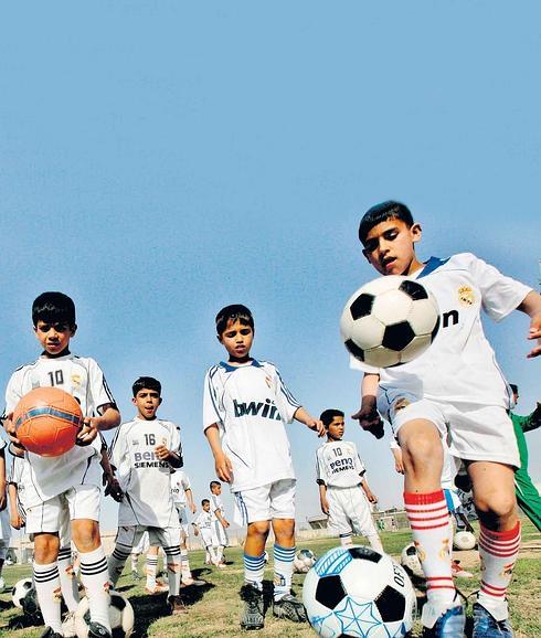 Niños iraquíes vestidos con la equipación del Real Madrid entrenan en una escuela de fútbol en Bagdad, la capital de Irak.