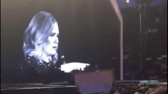 Adele señala a una fan durante la actuación.