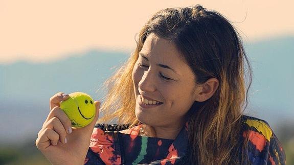 Garbiñe Muguruza posa junto a una pelota de tenis.