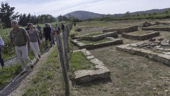 Los primeros visitantes de la temporada, a punto de entrar en el yacimiento de la necrópolis romana de Tribisburu, con sus mausoleos cuadrangulares.