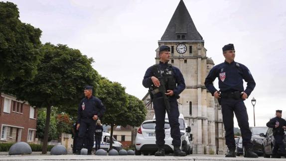 La Policía vigila la iglesia donde se cometió el crimen en Saint Etienne de Rouvray. A la derecha, un soldado patrulla las calles de Baiona, que celebra sus fiestas.