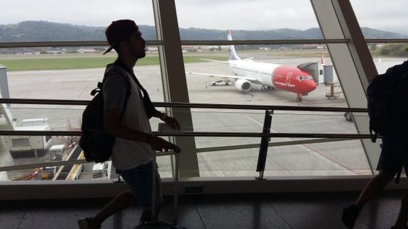 Un joven pasa frente a un avión de Norwegian.