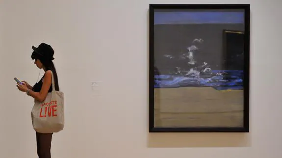 Una joven junto a una de las obras expuestas en el Guggenheim sobre Francis Bacon.