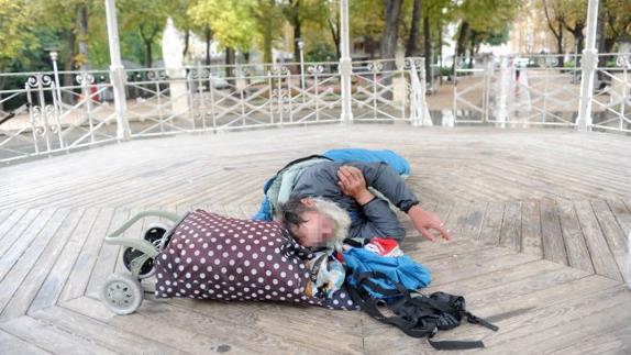 Una persona ‘sin techo’, ajena a esta información, duerme en el kiosco de La Florida. 