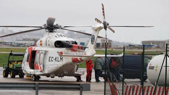 Momento de la llegada del helicóptero de Salvamento Marítimo, con el cuerpo rescatado del mar, al aeropuerto de Santander. 