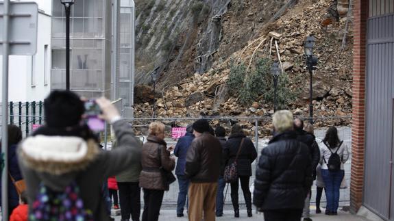 Vecinos observan las rocas caídas sobre las casas.