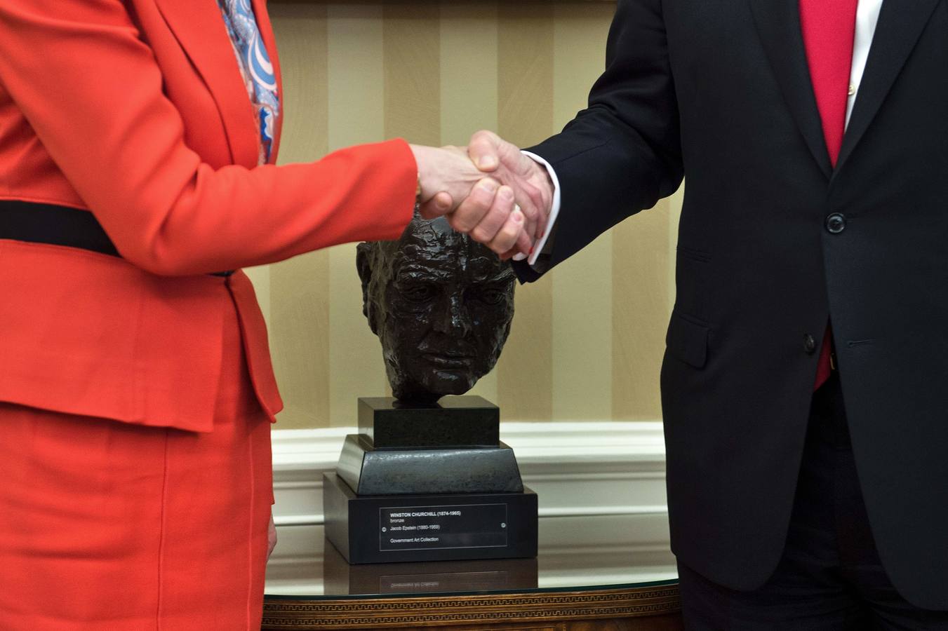 Trump y Theresa May se dan la mano delante del busto de Churchill en el Despacho Oval. 