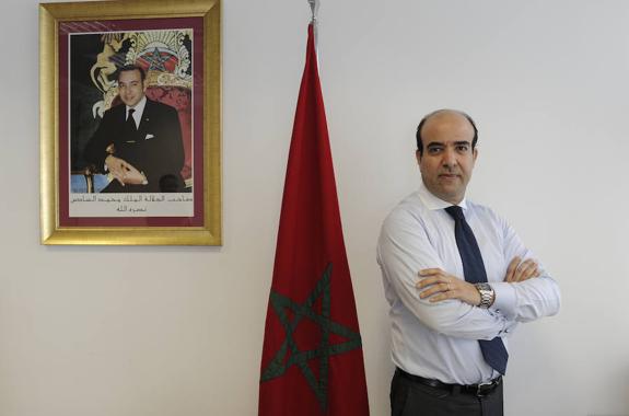 Kamal El Mahdaoui posa en su oficina de Bilbao junto a la bandera de Marruecos y el retrato del rey Mohamed VI.