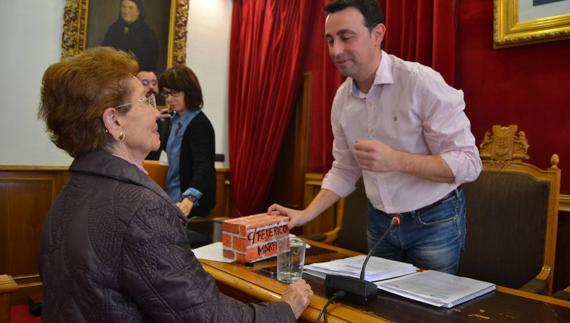 Juani le entrega el falso ladrillo a Mikel Torres, el alcalde.