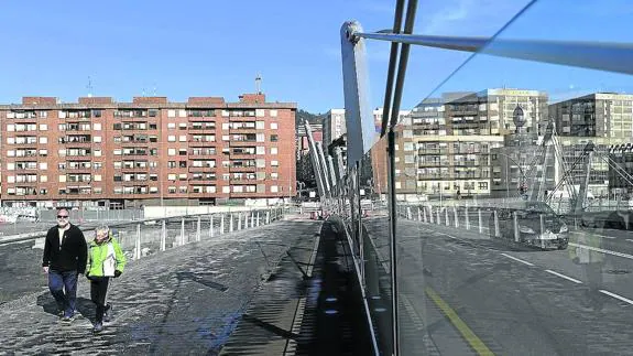 Una pareja camina por la acera del puente Gehry, único acceso a Zorrozaurre.