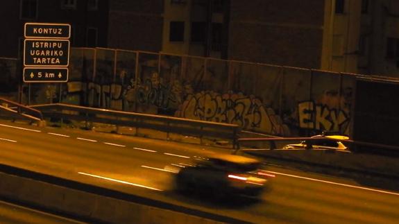 El coche de la Ertzaintza, aparcado en un lateral de la autopista.