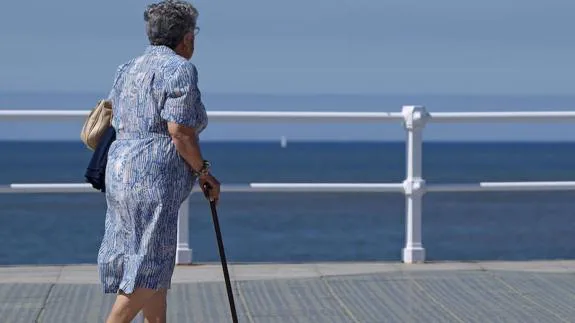 Una mujer pasea frente al mar.