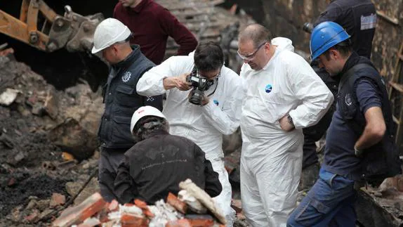 La Policía Científica de la Ertzaintza y los peritos buscan pruebas entre los restos del incendio.