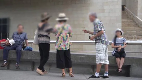 El hombre pide dinero a unas turistas japonesas a las que previamente ha sacado una foto.