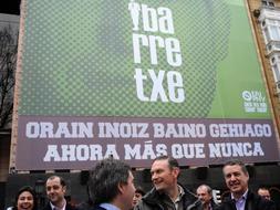 Ibarretxe y Urkullu, durante la colocación un cartel de apoyo al lehendakari en Sabin Etxea. / Ignacio Pérez