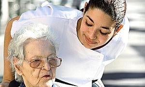 Una enferemera atiende a una anciana./ Fotolia