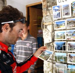 SOUVENIR. Valverde examina una postal de los Alpes. / EFE