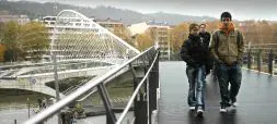 CONTROVERSIA. Varios peatones atraviesan ayer el empalme de Isozaki con la pasarela Calatrava, objeto del pleito que ha enfrentado al arquitecto con el Ayuntamiento de Bilbao. / MAITE BARTOLOMÉ