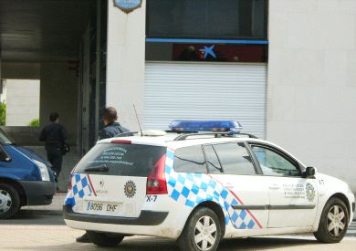 Un coche policial permanece junto a la oficina asaltada. / L. CALABOR