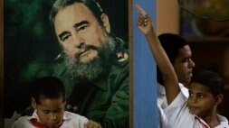 Escolares cubanos, frente a un gran retrato del líder de la revolución cubana. / AP