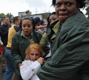 Dos mujeres policía arrastran a una participante en la marcha de las Damas de Blanco, que se resiste de forma pacífica. ::
AP