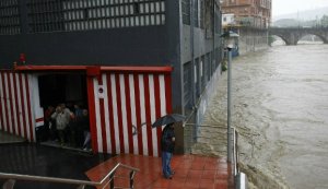 Un grupo de vecinos se resguardan de la lluvia en el interior de un garaje ubicado a escasos metros del cauce del río. ::                             MITXEL ATRIO