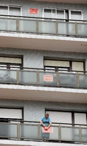 Una vecina coloca un cartel de protesta en su balcón. ::
MITXEL ATRIO