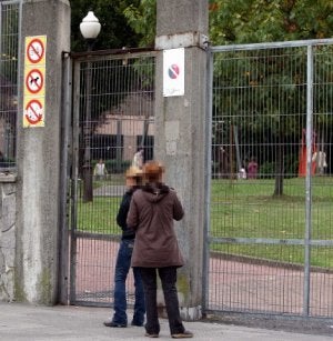 Dos madres aguardan a sus hijos a la entrada del colegio público de Txurdinaga. ::                             MITXEL ATRIO