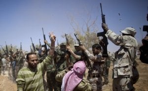 Rebeldes disparan al aire durante el funeral de un compañero muerto por las fuerzas de Gadafi. ::                             AP