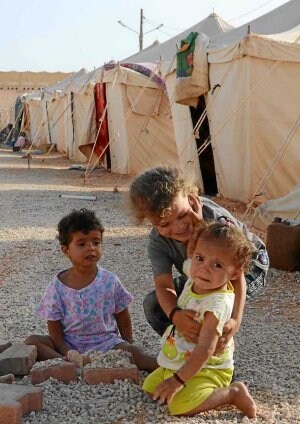 Tres niños juegan en un campamento. ::
M. AYESTARAN