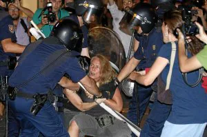 Los agentes antidisturbios tratan de reducir a una participante en la marcha laica de Madrid . ::                             EFE