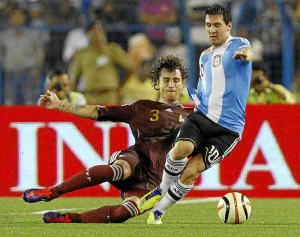 Fernando Amorebieta trata de impedir el avance de Lionel Messi en su debut con Venezuela. ::                             REUTERS