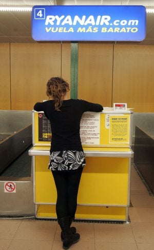 Una joven aguarda en un mostrador de Ryanair. /E.C.