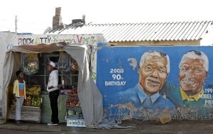 Venta de frutas junto a un muro con el rostro de Mandela. | REUTERS